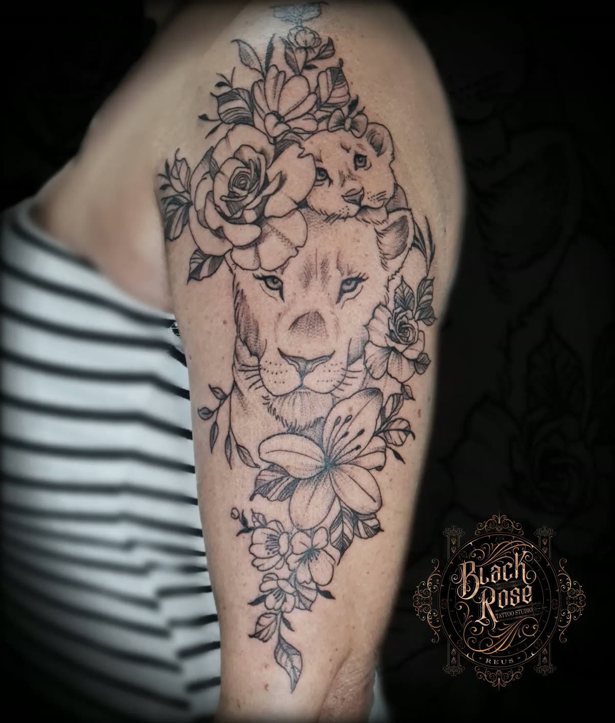 Hombro en línea fina: leona con su cachorro rodeada de rosas y lirios